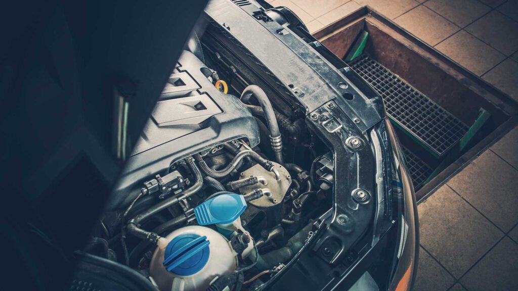 Offene Motorhaube, wo man von seitlich oben den Wasserbehälter für die den Kühler sehen kann.